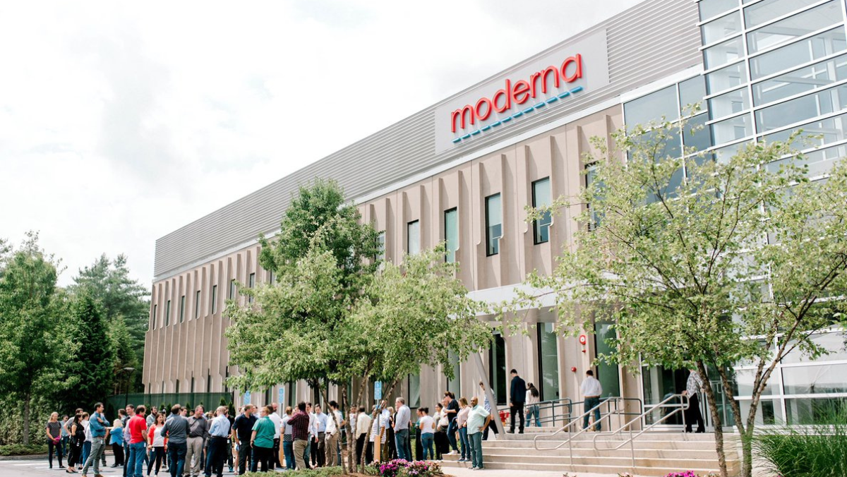 Crowd gathered outside Moderna headquarters building in daylight