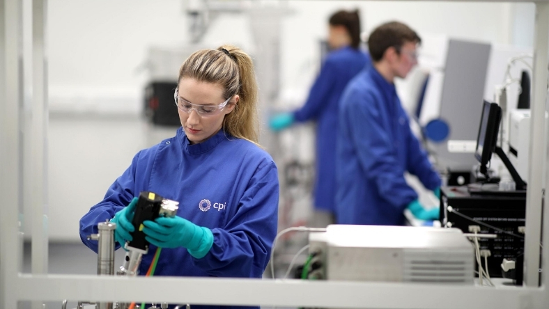 Laboratory technician working on RNA biomanufacturing equipment